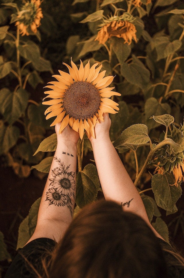 A girl with sunflower tattoo on her left arm