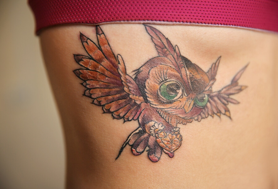 Owl tattoo on woman ribs