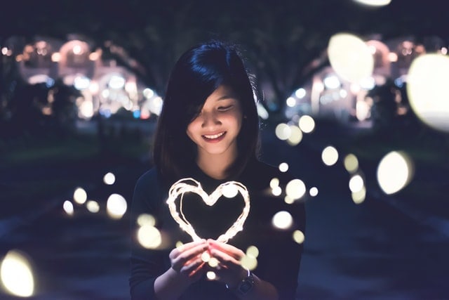 Girl holding heart-shaped light
