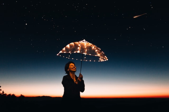 Girl holding umbrella under sky