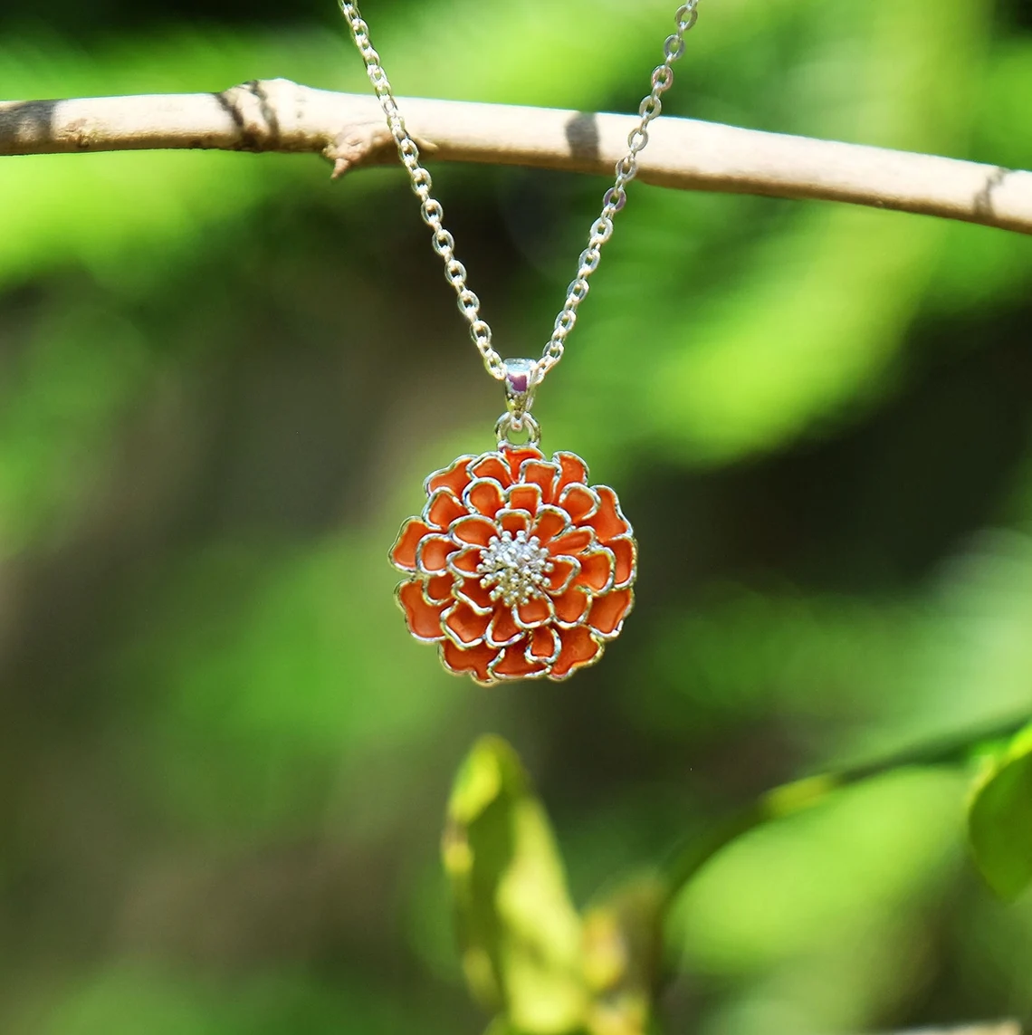 marigold pendant in yellow gold setting with green background