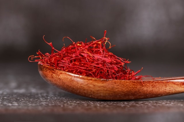 red saffron spice in a wooden spoon