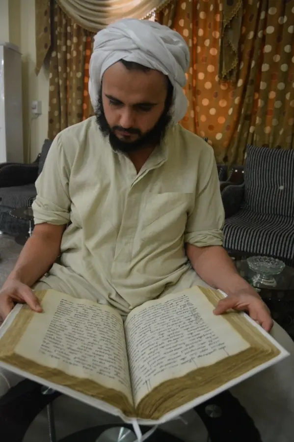a man reading an old mandaean manuscript