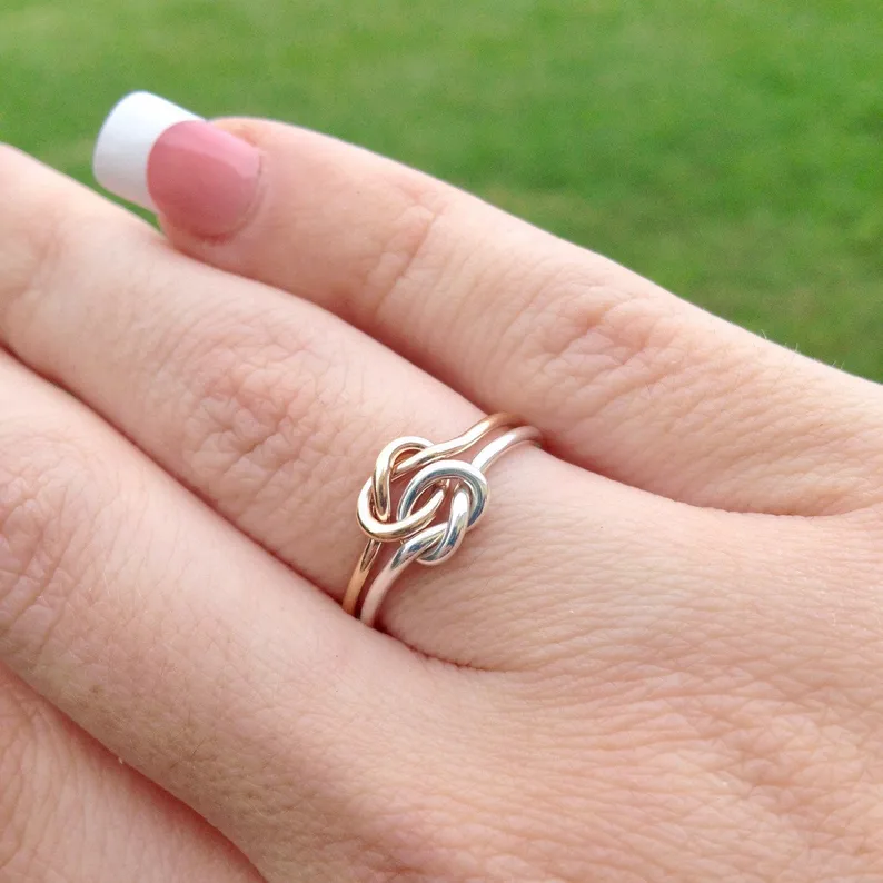 a hand with love knot ring