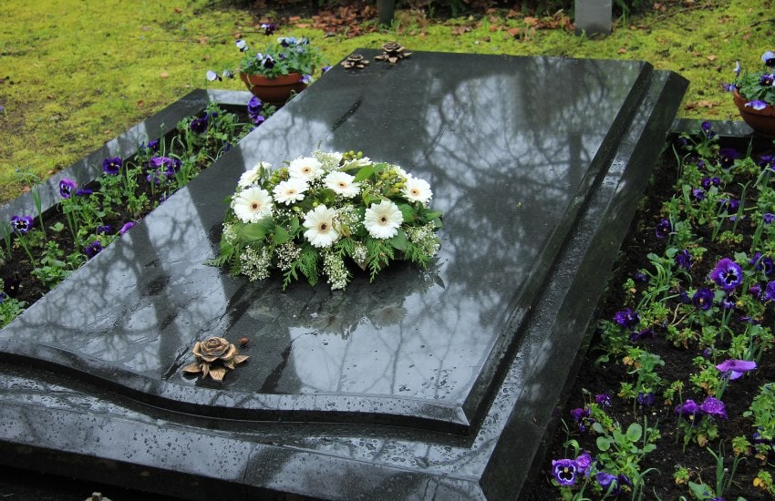 a black tomb with white flowers on top