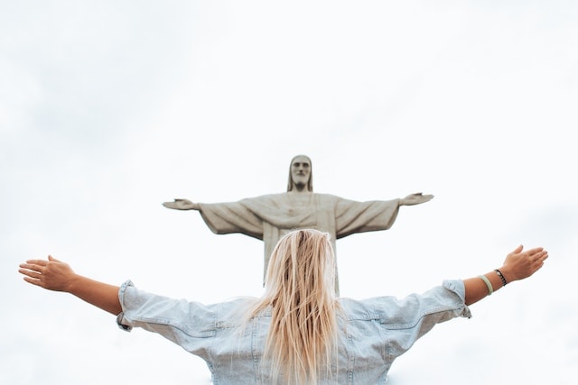 a woman in front of a Jesus statue