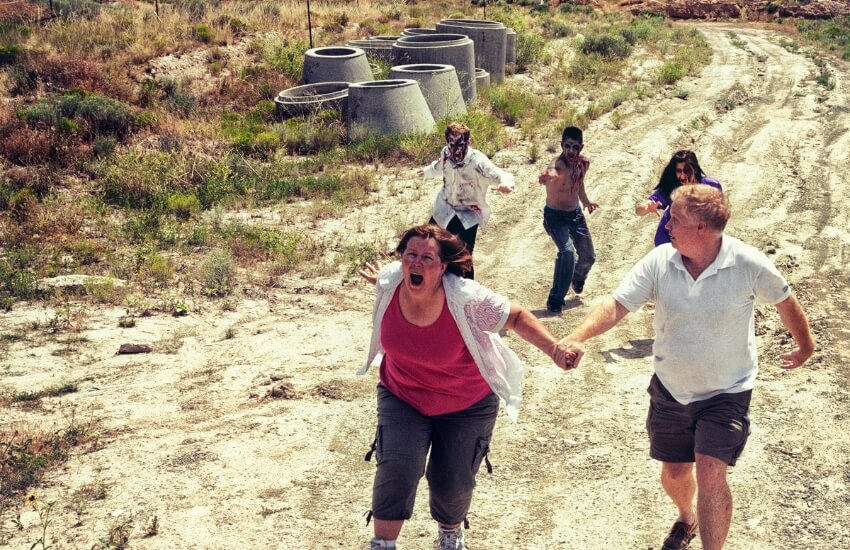a couple being chased by zombies