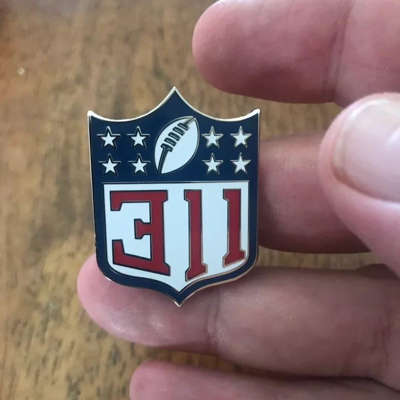a hand holding a 311 football nfl pin