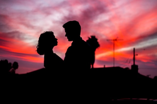 silhouette of couple facing each other during golden hour