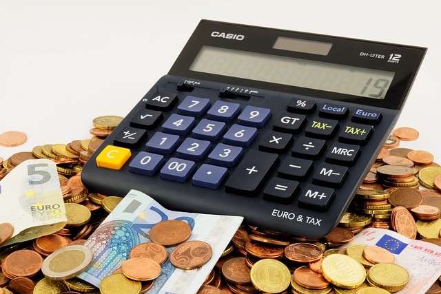 coins and bills under a calculator