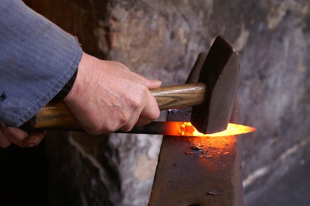 a person forging an iron metal