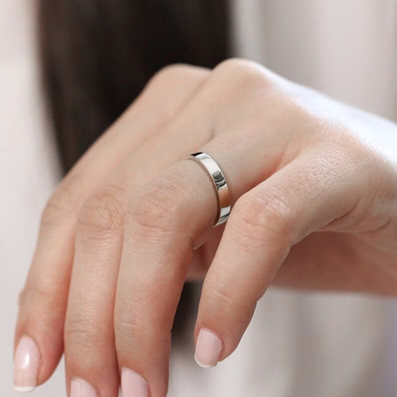 a hand with platinum wedding ring