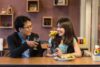 Cheers and conversation between a man and woman at a dining table in a cozy restaurant setting.